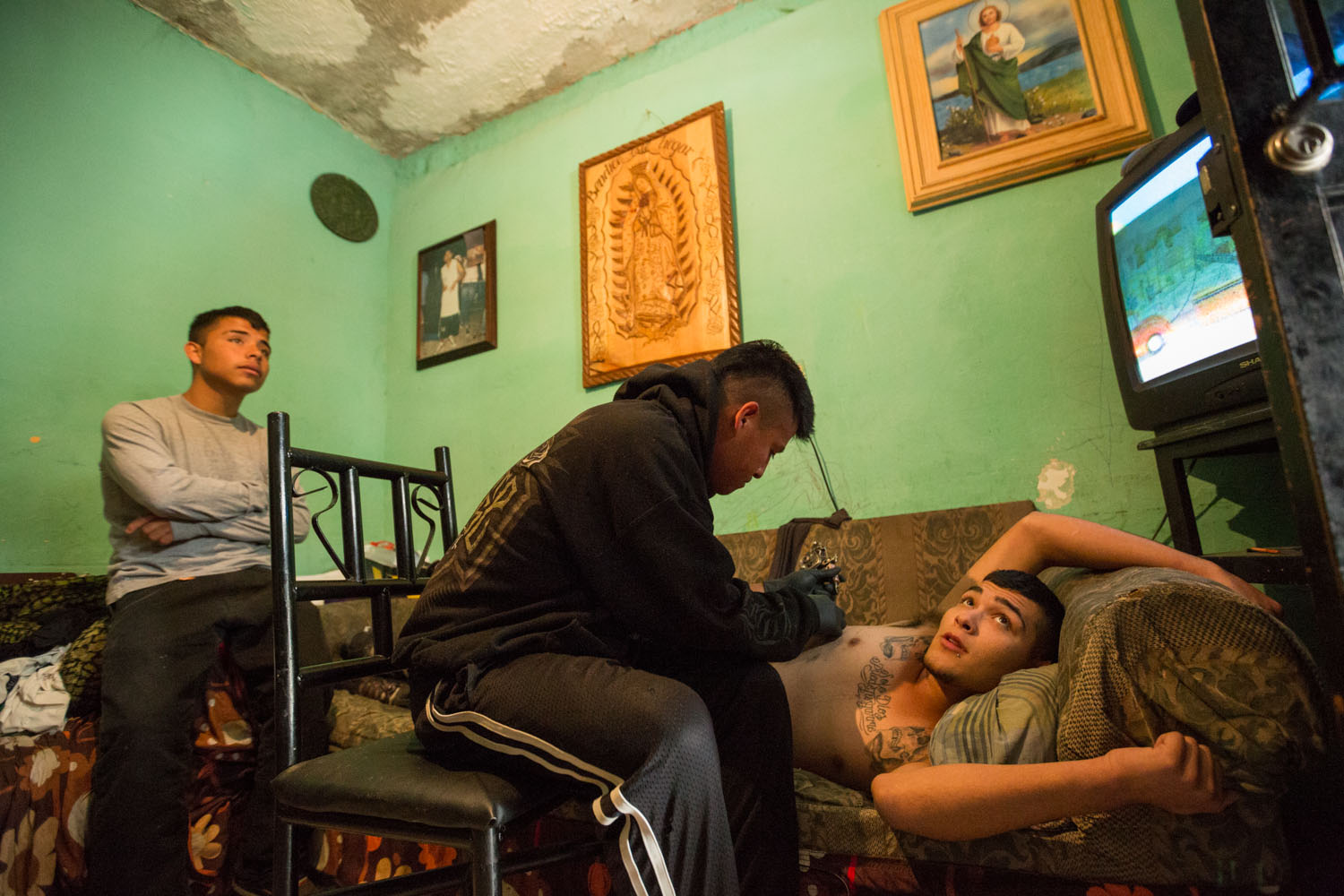 Dans le quartier del Ojo de Agua avec la bande des Millionarios. Un des jeunes de la banda se fait tatouer.           Saltillo, Coahuila, Mexique