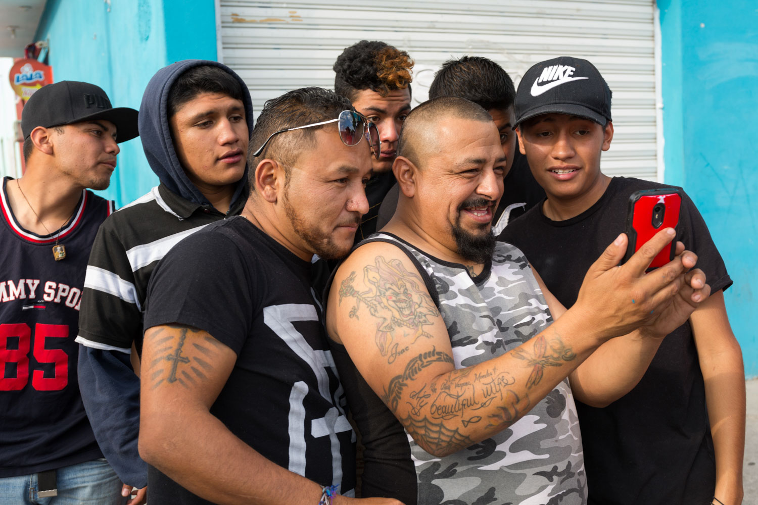 El Mijis stands with the gang of his childhood, los Chondos de las Dos Grifota, in the neighborhood of las Piedras. El Rana, his actual right hand as deputy, shows him videos of projects where he appears. 
Col. Las Piedras, San Luis Potosi, SLP, Mexico - 05/03/2017.

El Mijis est avec la bande de son enfance, los Chondos de las Dos Grifota, au quartier de las Piedras. El Rana, son actuel bras droit en tant que député, lui montre des vidéos de projets où il apparaît.
Col. La Piedras, San Luis Potosi, SLP, Mexique - 05/03/2017.