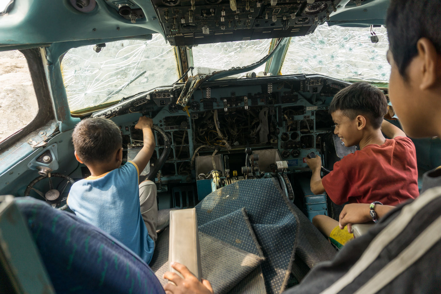 Paranaque, Grand Manille, Philippines. Des enfants jouent dans le cockpit d'un avion abandonné sur un terrain proche de chez eux.