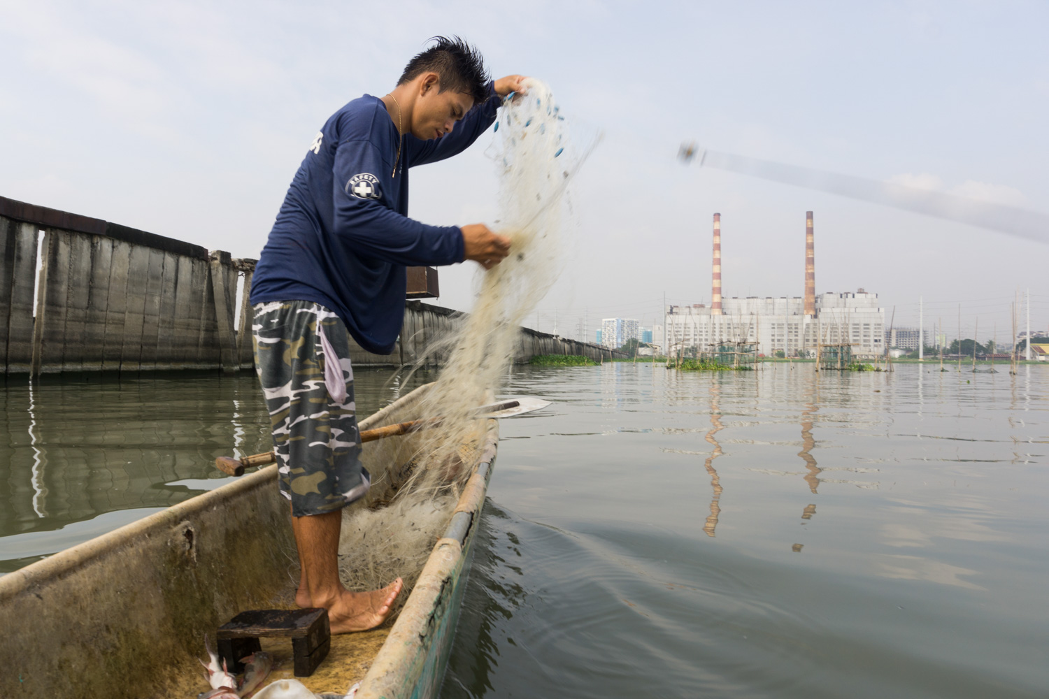 Eman goes fishing early in the morning on the lake "Laguna de Bay" with his old boat. He is near the water evacuation system of the electric central which is today abandonned after a typhoon.  
Buli, Muntinlupa, Metro Manila, Philippines - 12/01/2016.