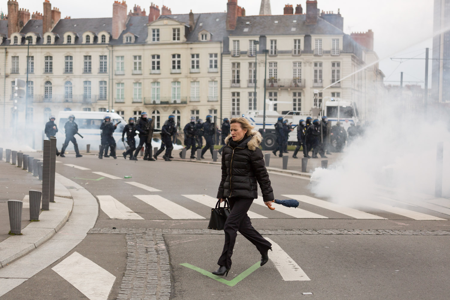 Recap of three months of social struggle against the El Khomri labour law project in Nantes during spring 2016. 
A woman got surprised inside exchanges of tear gas and missiles sent by the police and demonstrators. She runs to escape. 
Nantes, France - 31/03/2016. 

Retour sur trois mois de mouvements sociaux contre le projet de loi travail El Khomri à Nantes pendant le printemps 2016.  
Une femme qui s'est faite surprendre par les échanges de gaz lacrymogènes et de projectiles entre police et manifestants court pour s'échapper. 
Nantes, France - 31/03/2016.