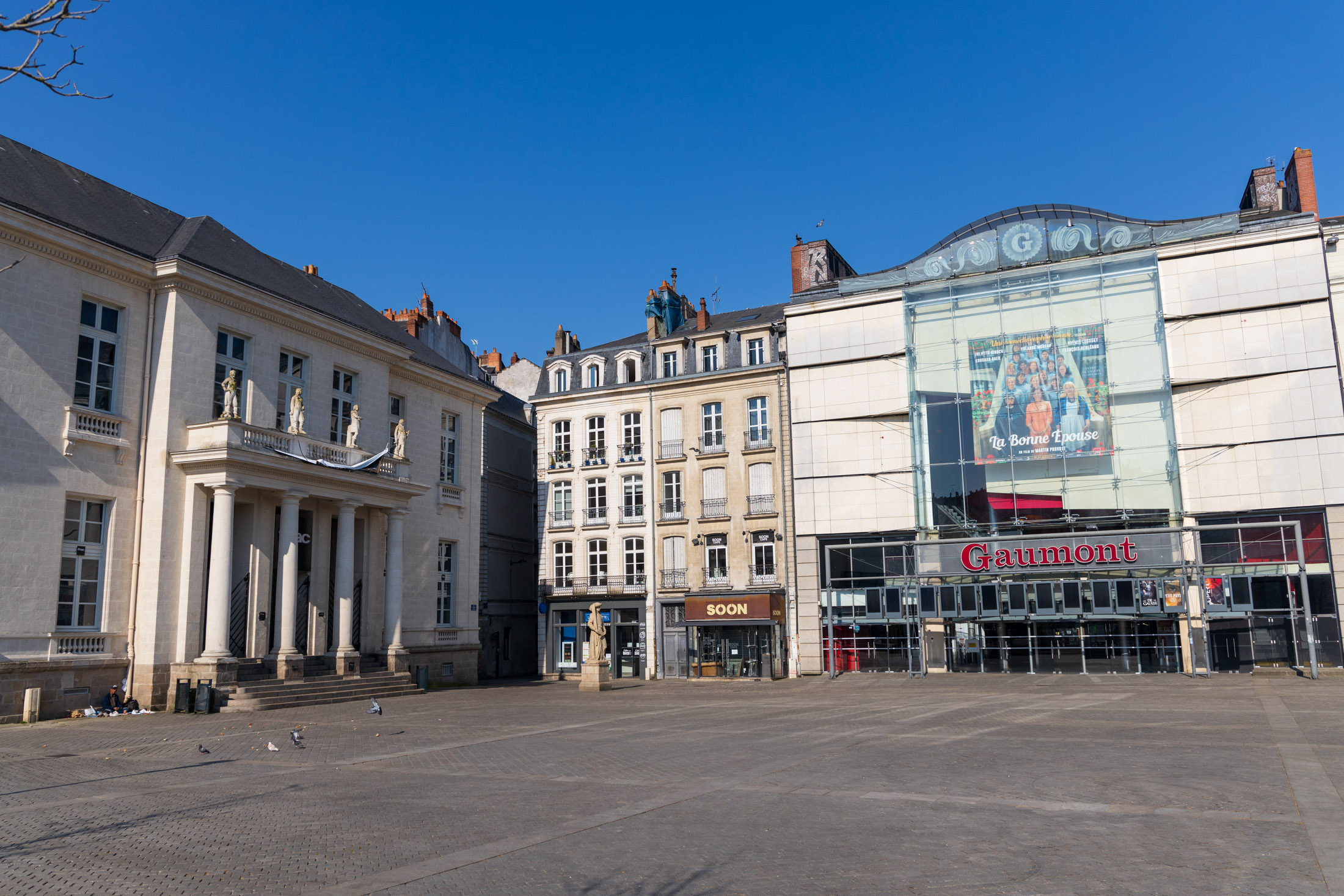 One of the major place of Nantes, the Place du Commerce, is almost empty. A homeless person gives food to pigeons. Nantes, France - April 2nd 2020.
Une des places majeures de Nantes, la Place du Commerce, est presque vide. Un sans-abri donne a manger aux pigeons. Nantes, France - 2 avril 2020.